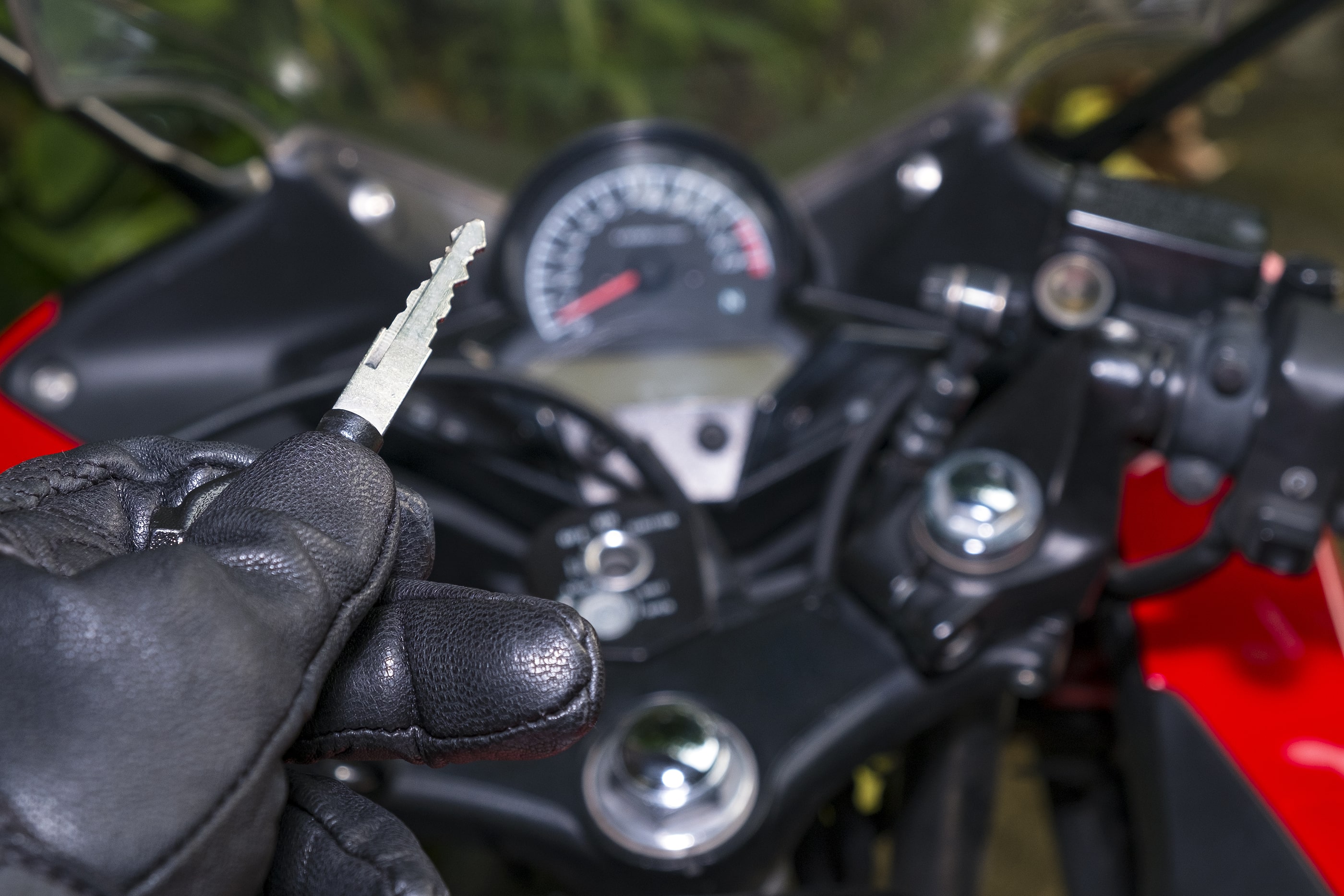 Person holding a motorcycle key on their motorcycle
