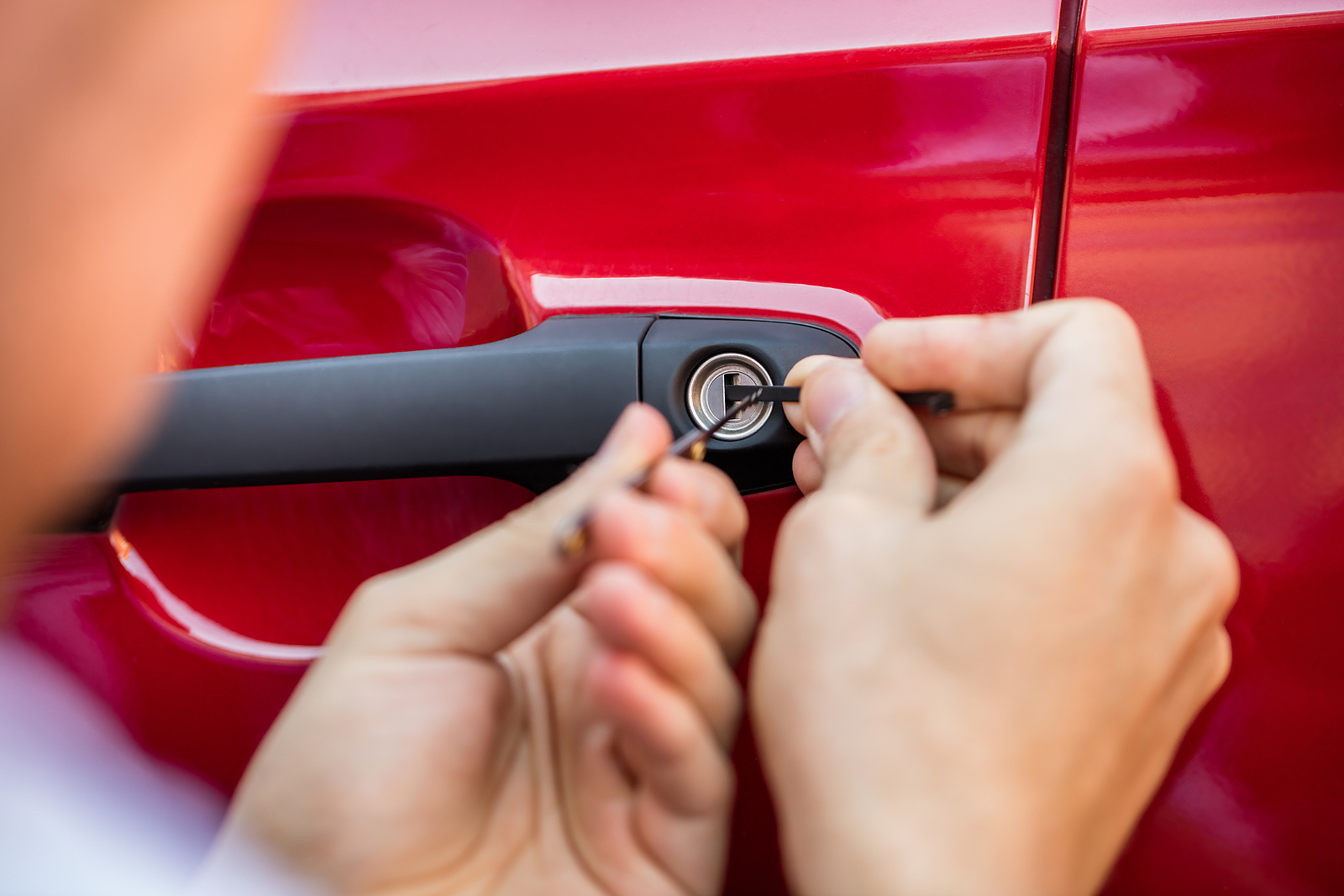 Close-up Of Person's Hand Opening Car Door With Lockpicker