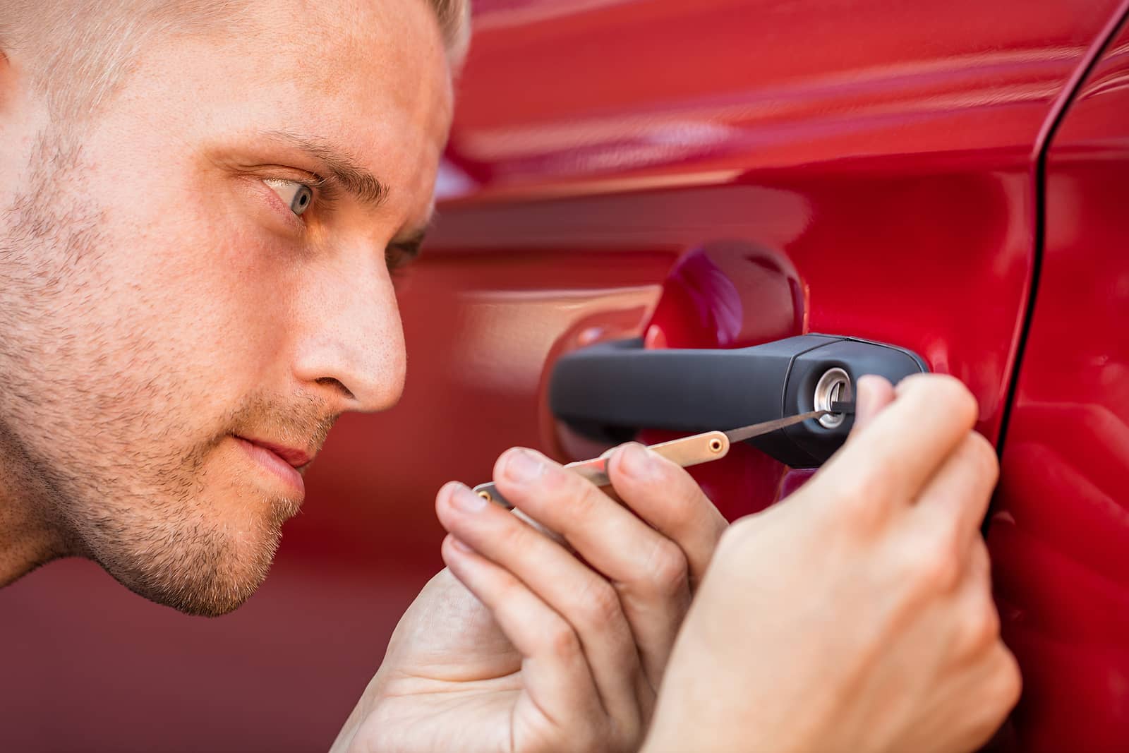 Jeep Locksmith Madison – Kwik Pick Locksmith Service – Close-up of a professional locksmith unlocking a red Jeep vehicle door using specialized tools, representing expert lockout assistance, key replacement, and ignition repair services in Madison, MS.